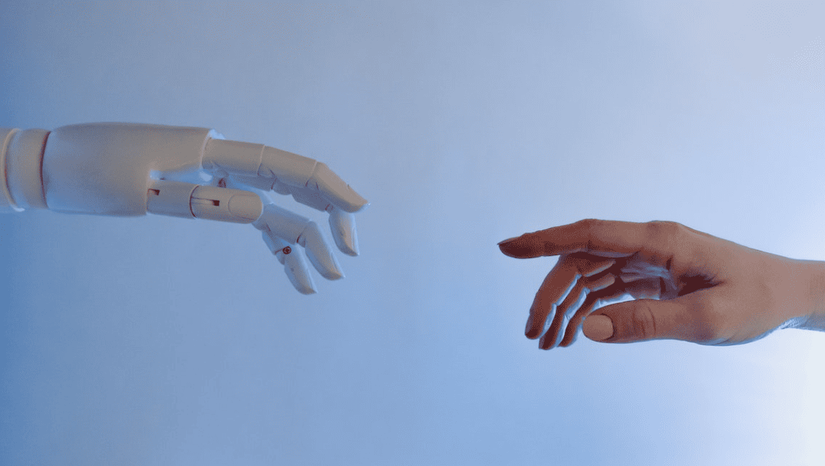 Robot hand reaching out to human hand.